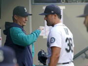 Seattle Mariners starting pitcher Robbie Ray, right, talks with manager Scott Servais in the dugout before the team's baseball game against the Texas Rangers, Tuesday, April 19, 2022, in Seattle. (AP Photo/Ted S.