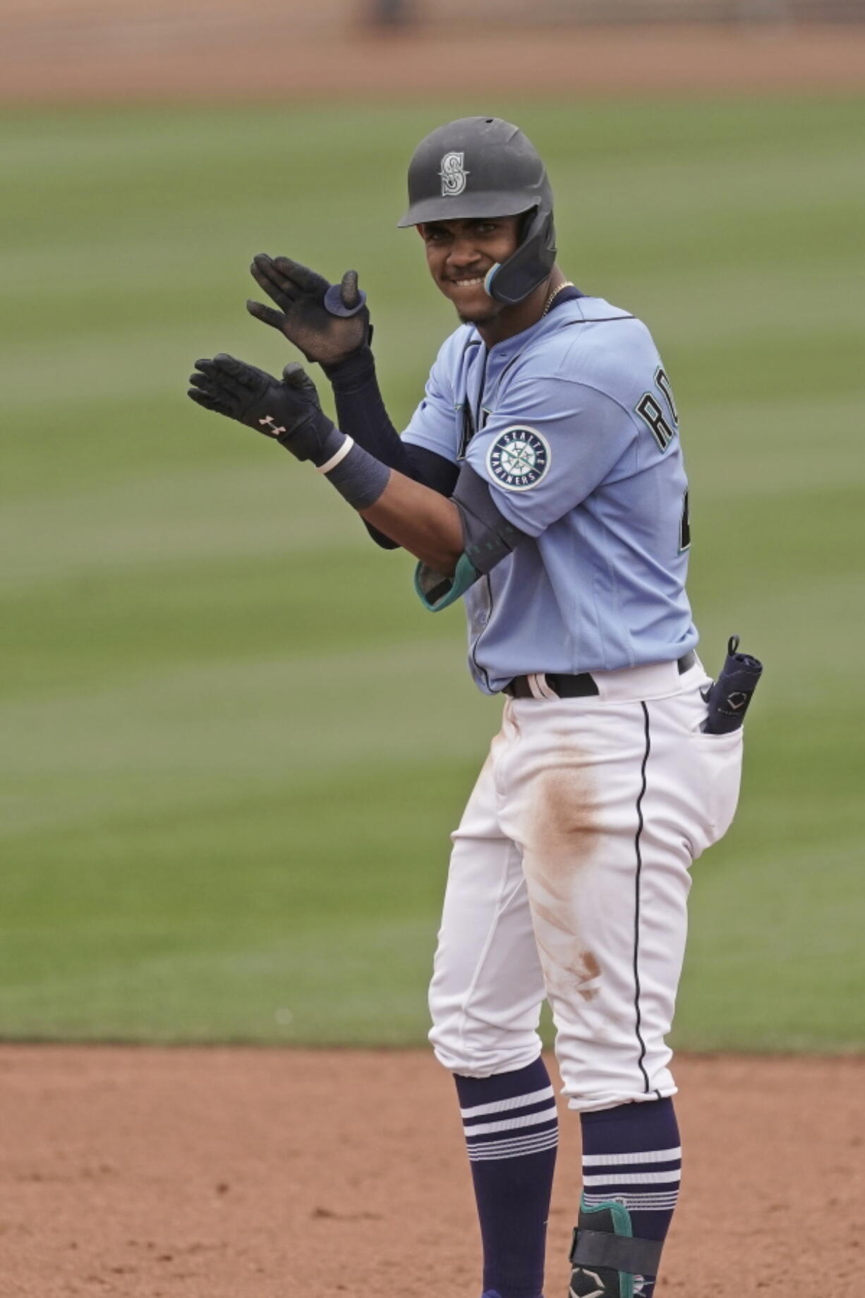 Seattle Mariners' Julio Rodriguez celebrates on second after hitting an RBI double during the fifth inning of a spring training baseball game against the Texas Rangers Monday, March 28, 2022, in Peoria, Ariz.