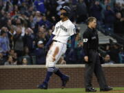 Seattle Mariners' Julio Rodriguez, left, reacts after scoring off a triple by Jarred Kelenic during the fourth inning of a baseball game against the Kansas City Royals, Friday, April 22, 2022, in Seattle.