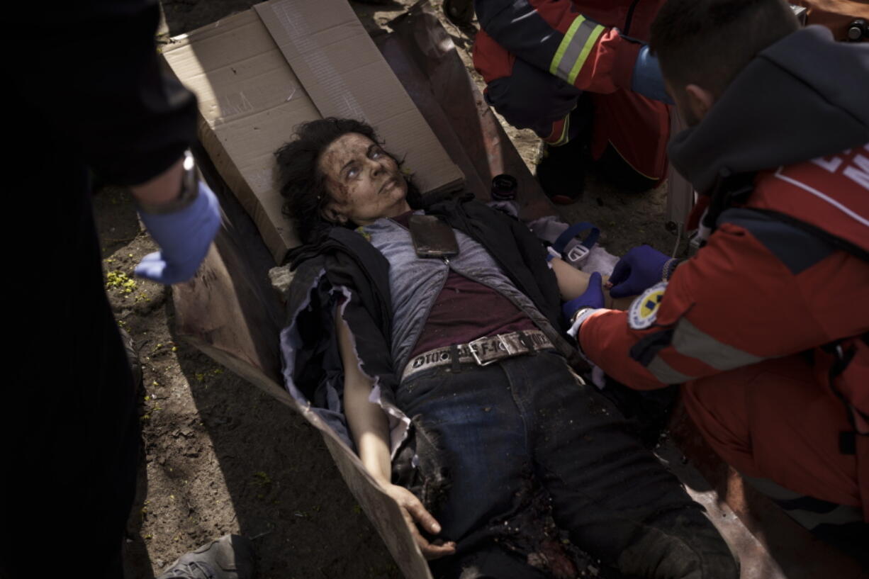 A woman injured in a Russian attack is treated by emergency workers in Kharkiv, Ukraine, Saturday, April 16, 2022.