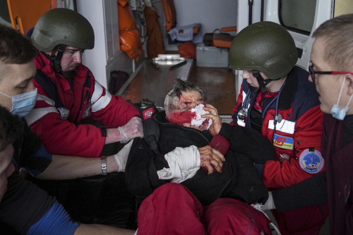 FILE - Ambulance paramedics move a civilian wounded in shelling onto a stretcher to a maternity hospital converted into a medical ward in Mariupol, Ukraine, March 2, 2022. A bipartisan group of U.S.