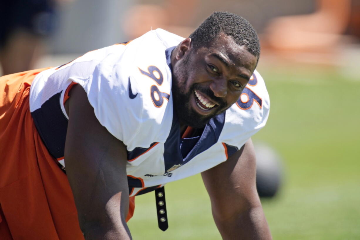 FILE- Denver Broncos defensive end Shelby Harris jokes with teammates as they take part in drills during NFL football training practice at the team's headquarters on Aug. 25, 2021, in Englewood, Colo. For both Shelby Harris and Noah Fant, their unexpected offseason move joining the Seattle Seahawks feels a bit like an eventuality finally coming true.