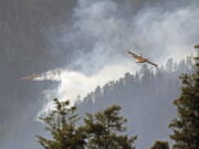 In this photo released by the U.S. Forest Service, aircraft known as "super scoopers" battle the Hermits Peak and Calf Canyon Fires in the Santa Fe National Forest in New Mexico on Tuesday, April 26, 2022. Firefighters have been making significant progress on the biggest wildfires burning unusually hot and fast for this time of year in the western U.S. But forecasters from the Southwest to the southern High Plains are warning of the return the next two days of the same gusty winds and critical fire conditions that sent wildland blazes racing across the landscape last week. (J. Michael Johnson/U.S.