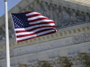 FILE - An American flag waves in front of the Supreme Court building, Nov. 2, 2020, on Capitol Hill in Washington.