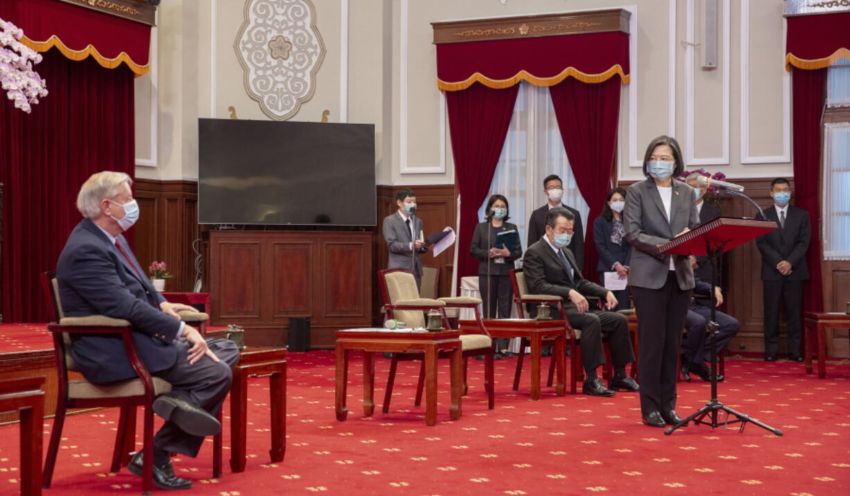 In this photo released by the Taiwan Presidential Office, Sen. Lindsey Graham, R-S.C., left, listens as Taiwan's President Tsai Ing-wen, right, speaks during a meeting at the Presidential Office in Taipei, Taiwan, Friday, April 15, 2022. U.S. lawmakers visiting Taiwan have made a pointed and public declaration of their support for the self-governing island democracy while also issuing a warning to China.