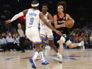 Portland Trail Blazers guard CJ Elleby (16) drives the ball against Trail Blazers guard Zavier Simpson (9) and forward Jaylen Hoard (14) during the first half of an NBA basketball game Tuesday, April 5, 2022, in Oklahoma City.