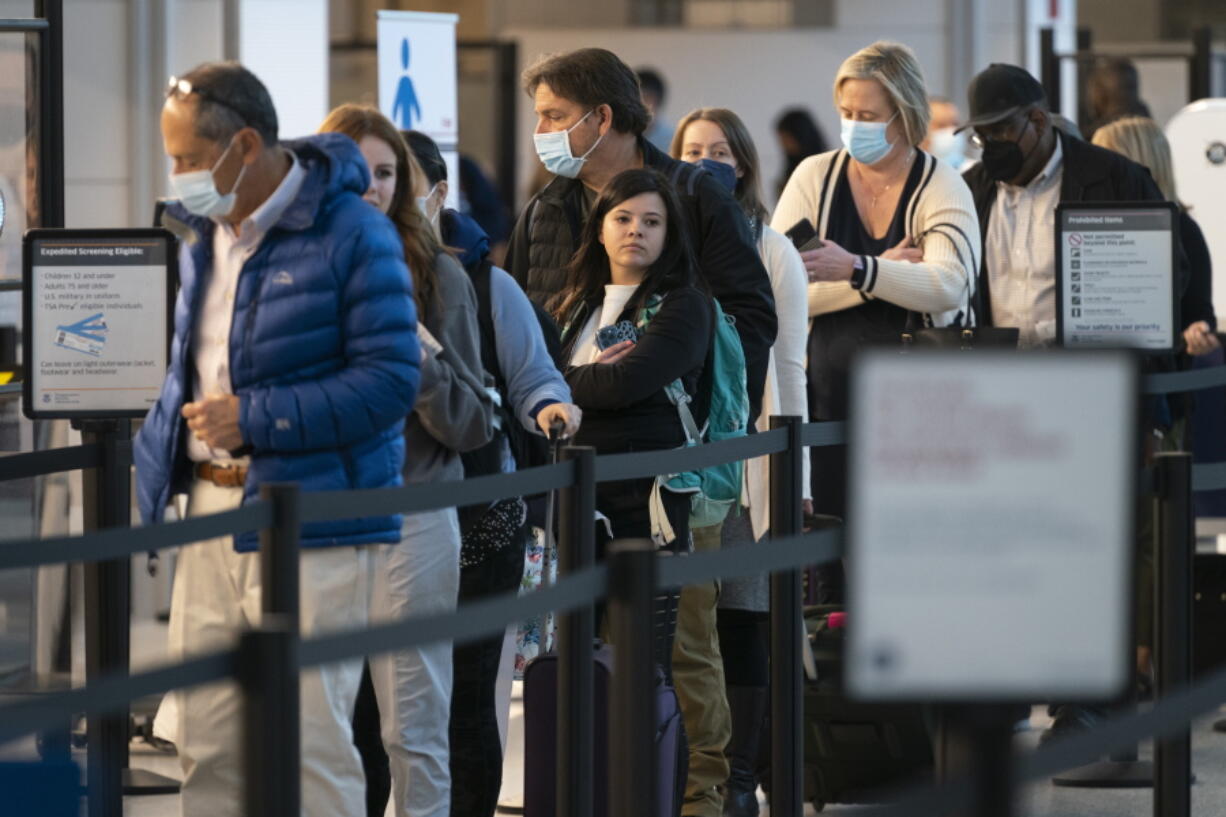 Passengers wait in line at the security checkpoint at Ronald Reagan Washington National Airport, Tuesday, April 19, 2022, in Arlington, Va. A federal judge's decision to strike down a national mask mandate was met with cheers on some airplanes but also concern about whether it's really time to end the order sparked by the COVID-19 pandemic.