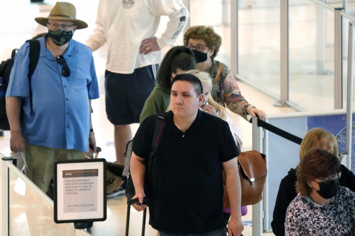 Travelers wait in a security line at Love Field in Dallas, Tuesday, April 19, 2022. The major airlines and many of the busiest airports dropped their mask requirements after a Florida judge struck down the CDC mandate and the Transportation Security Administration announced it wouldn't enforce its 2021 security directive.