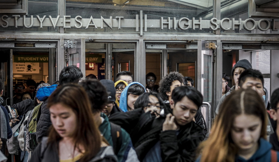 FILE - Students at Stuyvesant High School leave after classes end for the week, March 13, 2020, in New York. Schools across America are racing to make up for lost classroom time, budgeting billions of dollars for tutoring, summer camps and longer school days. But figuring out which students need help has become its own challenge after the pandemic left holes in some students' learning records. New York City is adding three rounds of testing this year, hoping to pinpoint which students are behind and where.