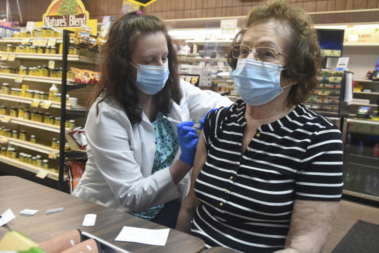 FILE - Pharmacist Karen Flynn gives a second Moderna booster shot to her mother Joann Pangonis, of New Boston, Pa., at Morris Drug in Mahanoy City, Pa., on Friday, April 1, 2022.  An extra-contagious version of the omicron coronavirus variant has taken over the world. The variant scientists call BA.2 is now dominant in at least 68 countries, including the U.S. The World Health Organization says it makes up about 94% of sequenced omicron cases submitted in the most recent week to an international database.