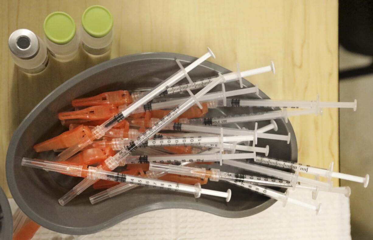 FILE - Medical personnel place pre-loaded syringes as they vaccinate students at KIPP Believe Charter School in New Orleans, Jan. 25, 2022. While many Americans are trying to move on with their lives after two years of the coronavirus pandemic, U.S. health officials are only beginning to decide on a strategy for using the COVID-19 vaccines to stay ahead of the outbreak. A panel of vaccine experts is meeting Wednesday, April 6, 2022 to discuss key questions for future COVID-19 booster campaigns, including how often the shots should be updated against new viral strains and who should get them.