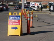 FILE - A sign points to a COVID testing site at the Cincinnati Veterans Affairs Medical Center in Cincinnati, on Jan. 3, 2022. COVID-19 hospitalization numbers have plunged to their lowest levels since the early days of the pandemic, offering a much needed break to health care workers and patients alike following the omicron surge. The number of patients hospitalized with the coronavirus has fallen more than 90% in more than two months, and some hospitals are going days without a single COVID-19 patient in the ICU for the first time since early 2020.