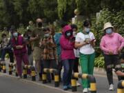 Residents wearing masks line up for mass COVID testing in Chaoyang District on Monday, April 25, 2022, in Beijing.