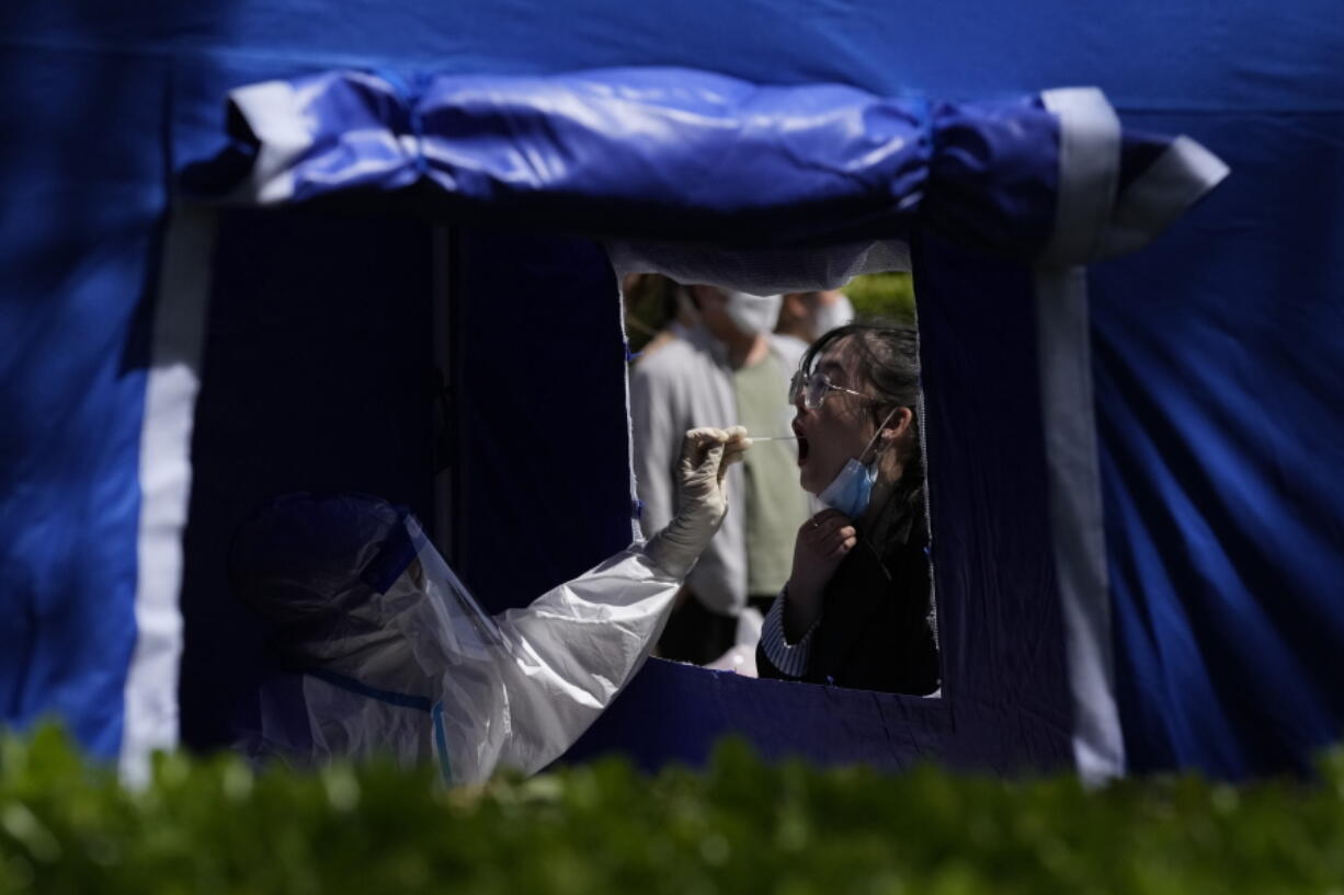 A resident gets tested outside an office building in the Haidian district on Tuesday, April 26, 2022, in Beijing. China's capital Beijing is enforcing mass testing and closing down access to neighborhoods as it seeks to contain a new COVID-19 outbreak.