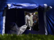 A resident gets tested outside an office building in the Haidian district on Tuesday, April 26, 2022, in Beijing. China's capital Beijing is enforcing mass testing and closing down access to neighborhoods as it seeks to contain a new COVID-19 outbreak.