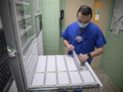 In this image provided by the U.S. Army, U.S. Air Force 2nd Lt. Kaelan Hayes, a clinical nurse assigned to the military medical team deployed to Brockton, Mass., gathers medication as part of the COVID-19 response operations at Signature Healthcare Brockton Hospital, March 15, 2022. (Sgt. Kaden D. Pitt/U.S.