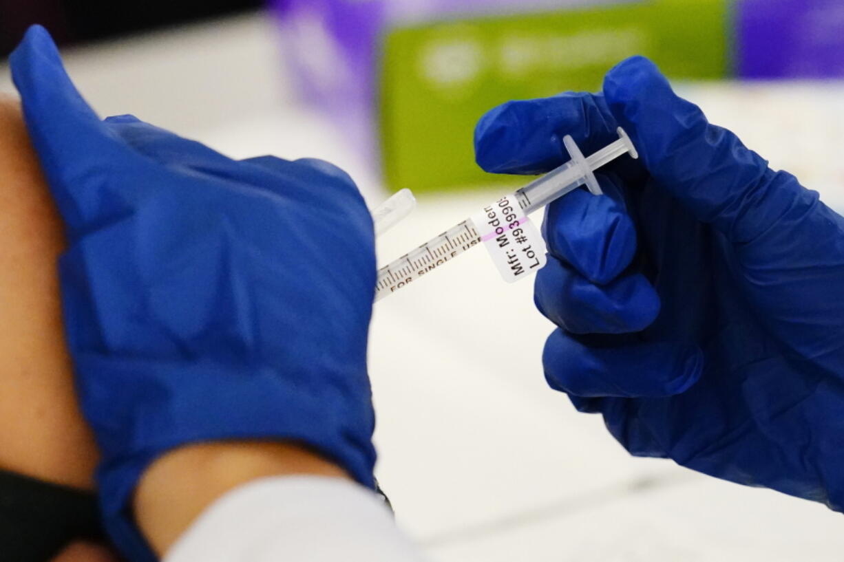 FILE - A health worker administers a dose of a Moderna COVID-19 vaccine during a vaccination clinic in Norristown, Pa., Tuesday, Dec. 7, 2021.  Moderna on Thursday, April 28, 2022,  asked U.S.