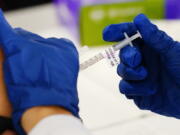 FILE - A health worker administers a dose of a Moderna COVID-19 vaccine during a vaccination clinic in Norristown, Pa., Tuesday, Dec. 7, 2021.  Moderna on Thursday, April 28, 2022,  asked U.S.