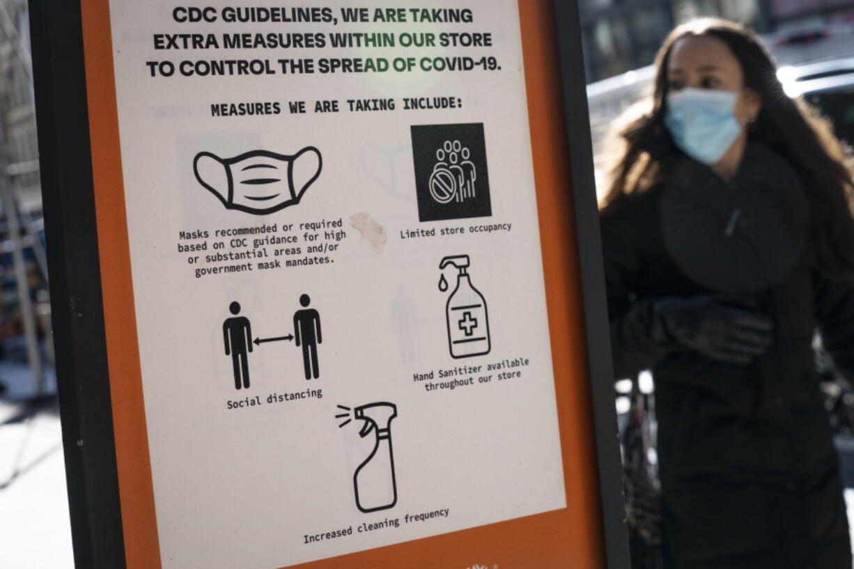 FILE - Pedestrians wearing protective masks walk along Broadway in the SoHo district of New York, Friday, March 4, 2022. COVID-19 hospitalization numbers have plunged to their lowest levels since the early days of the pandemic, offering a much needed break to health care workers and patients alike following the omicron surge.