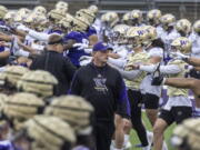 University of Washington coach Kalen Deboer walks among players and staff as they perform early morning warmups during NCAA football practice, Wednesday, March 30, 2022.