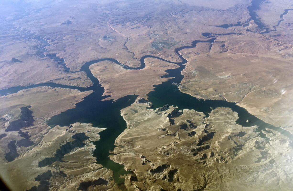 FILE - An aerial view of Lake Powell on the Colorado River along the Arizona-Utah border on Sept. 11, 2019. A dam holds back Lake Powell, one of the largest man-made reservoirs in the country. Federal officials sent seven western states a letter this week warning them that they're considering cutting the amount of water that flows through the Colorado River to the Southwest to maintain Lake Powell and prevent it from shrinking to a point at which Glen Canyon Dam could no longer produce hydropower. Consideration of what would be an unprecedented move comes sooner than water officials expected as they reckon with the effects drought and climate change have on their urban and agricultural customers.