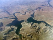 FILE - An aerial view of Lake Powell on the Colorado River along the Arizona-Utah border on Sept. 11, 2019. A dam holds back Lake Powell, one of the largest man-made reservoirs in the country. Federal officials sent seven western states a letter this week warning them that they're considering cutting the amount of water that flows through the Colorado River to the Southwest to maintain Lake Powell and prevent it from shrinking to a point at which Glen Canyon Dam could no longer produce hydropower. Consideration of what would be an unprecedented move comes sooner than water officials expected as they reckon with the effects drought and climate change have on their urban and agricultural customers.