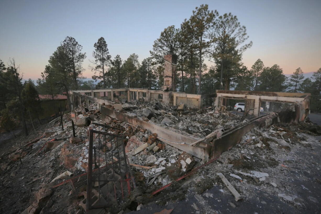 A two-story house continues to smolder following the McBride Fire in Ruidoso, New Mexico, on Thursday, April 14, 2022.   Authorities say firefighters have kept a wind-driven blaze from pushing further into a mountain community in the southern part of the state.