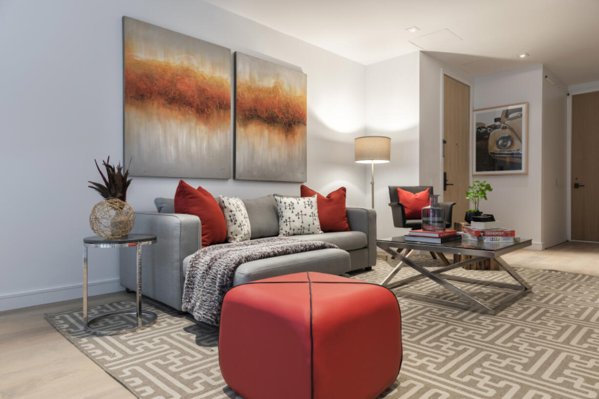 A small ottoman provides both a pop of color and additional seating in this family room.