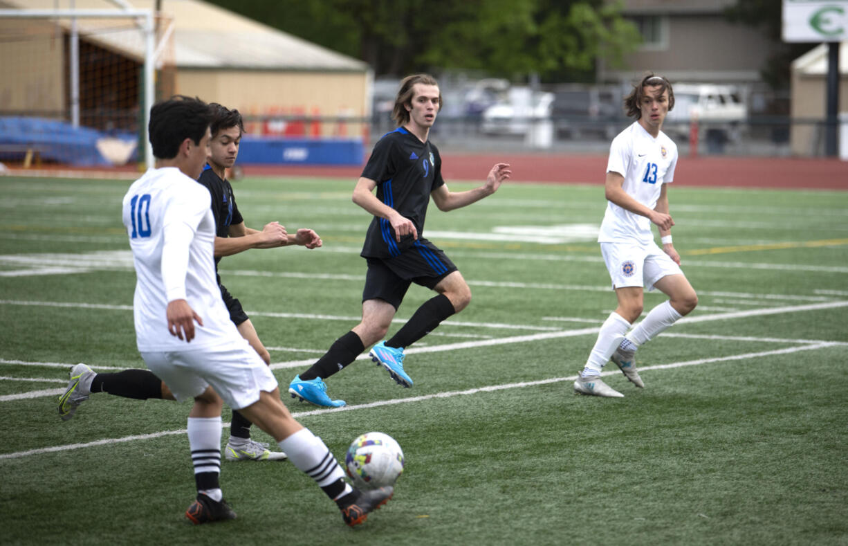 Stadium’s Jeremy Baez flicks a pass forward as Mountain View’s Nolan Brady, second from left, and Jordan Thornton defend in the second half of Saturday’s Class 3A bi-district game at McKenzie Stadium.