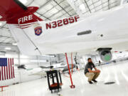 Mission Sensor Operator Wade Hutt checks out the large camera attached to the Pilatus multi-mission aircraft in a hangar at Centennial Airport at Centennial Airport on May 2, 2022, in Englewood, Colorado. This aircraft is used to detect fires, help with mapping of perimeters and give real time situational awareness of fires. The plane is also used for search and rescue operations, wildlife surveys, even avalanches. (Helen H.