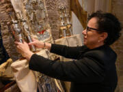 Rabbi Rachel Sabath Beit-Halachmi adjusts the crowns and breastplate of a sacred Torah scroll inside the sanctuary April 29 at Har Sinai-Oheb Shalom Congregation in Baltimore.