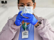 In this photo from March 25, 2021, licensed vocational nurse Denise Saldana prepares the single-dose Johnson & Johnson Janssen COVID-19 vaccine at a vaccine rollout targeting immigrants and the undocumented organized by the St. John's Well Child and Family Center and the Los Angeles County Federation of Labour and Immigrant rights groups in Los Angeles, California. Many career nurses turned to travel gigs during the pandemic, when hospitals crowded with COVID-19 patients urgently needed the help.(FREDERIC J.