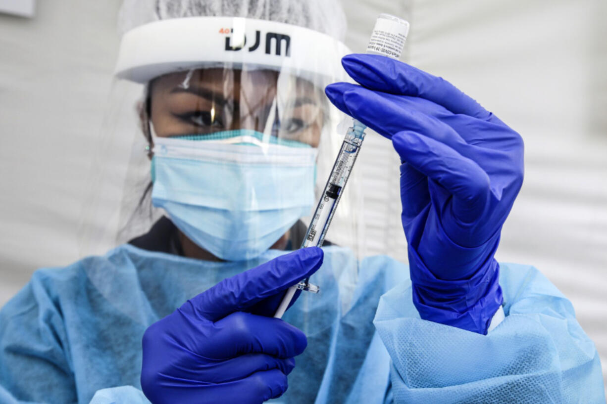 A nurse prepares a dose of Pfizer-BioNTech's COVID-19 vaccine at St. John's Well Child & Family Center in Los Angeles on Jan. 7, 2021.