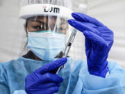 A nurse prepares a dose of Pfizer-BioNTech's COVID-19 vaccine at St. John's Well Child & Family Center in Los Angeles on Jan. 7, 2021.