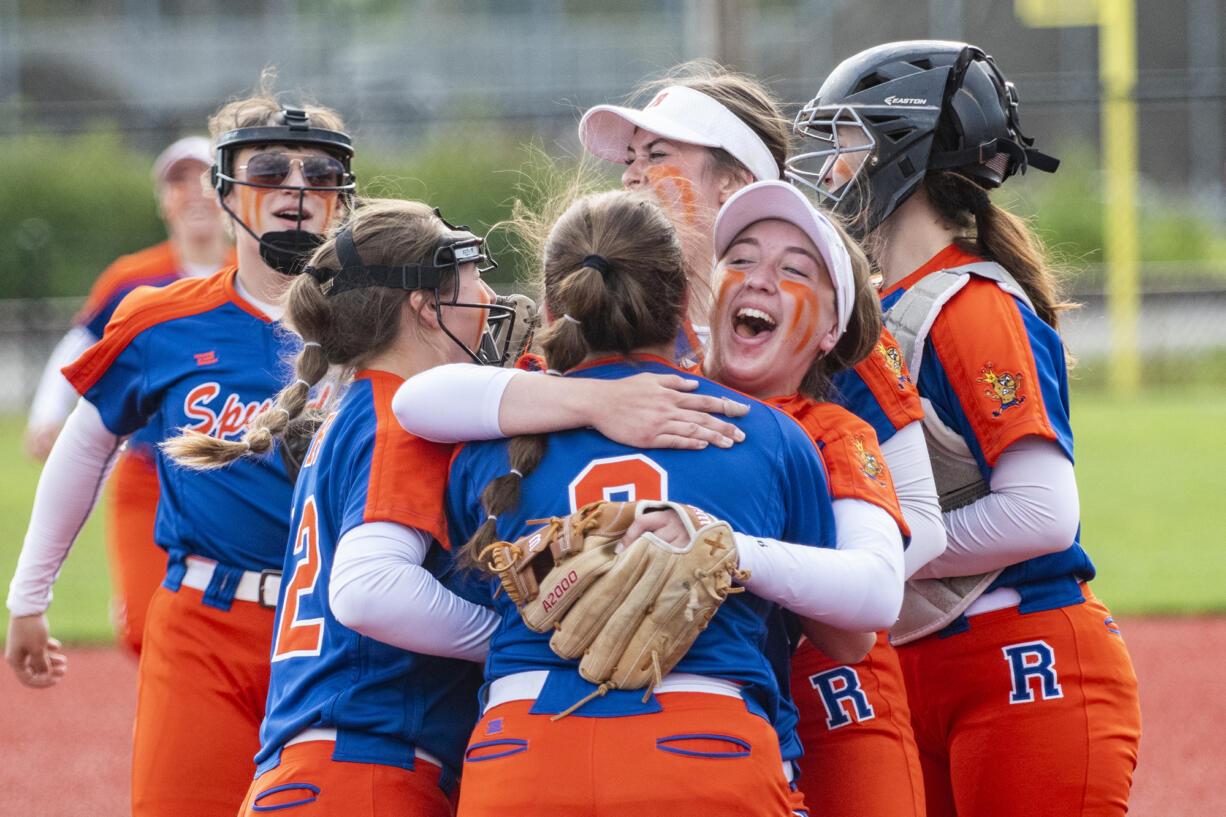 Ridgefield's Mallory Vancleave, center, hugs Elizabeth Peery (8) after the Spudders defeat R.A. Long to clinch a state berth during the 2A District IV playoffs at Recreation Park in Chehalis on May 20, 2022.