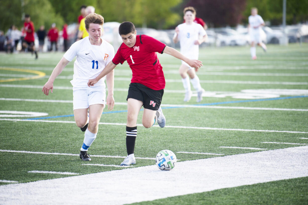 Fort Vancouver's Ernesto Coria Zavala (1) works against Ridgefield's Ashton Wagner during the Trappers' 2-0 win over Ridgefield in 2A boys soccer district playoff on Saturday, May 14, 2022.