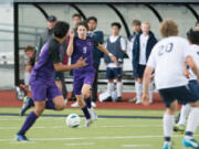 Columbia River's Alex Harris dribbles up the field against multiple Burlington-Edison defenders during the first half of the Class 2A state boys soccer semifinals on Friday.