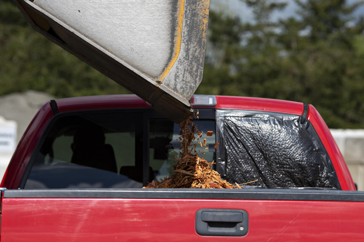 Cedar chips are loaded into the truck of a customer at Bark Ranch Landscape Supply on Wednesday morning.