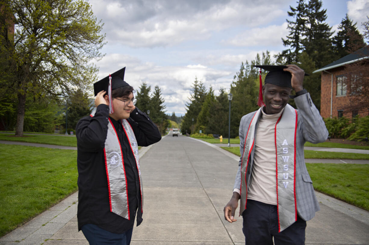 Graduating seniors and student leaders Armando Antonino, left, and Evans Kaame take a moment to try on some of their celebratory graduation garb on campus at Washington State University Vancouver on a Friday afternoon, reflecting on their final days as students.