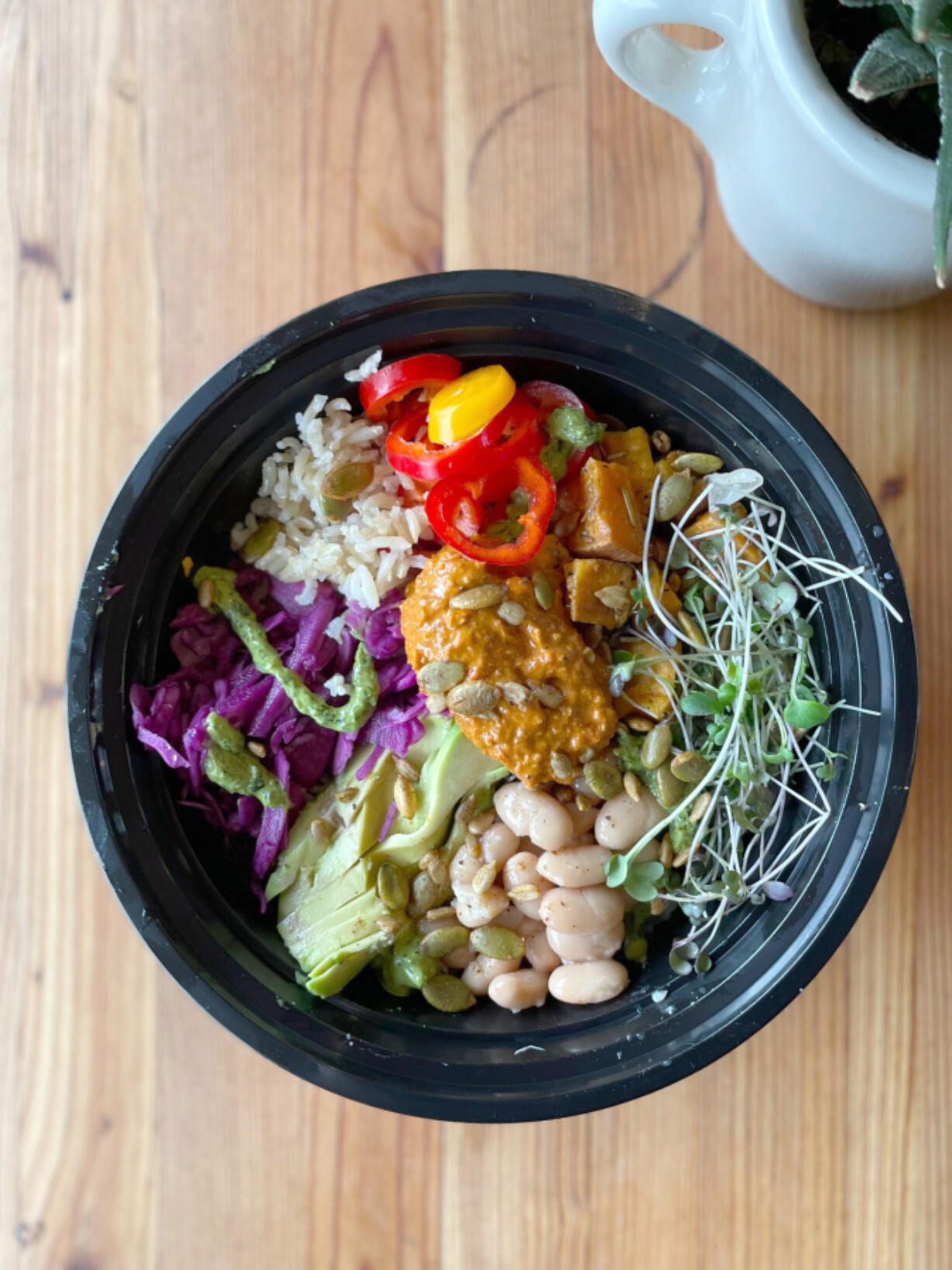 River Maiden's Amaze Bowl combines rice, white beans, cilantro garlic sauce, avocado, pickled cabbage, sliced sweet peppers, sweet potato, red pepper pesto and toasted seeds. The bowl also features micro greens from Red Truck Farm.