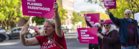 Abortion rights supporters encourage passing drivers to honk their car horns Tuesday evening at a rally outside the Clark County Courthouse.