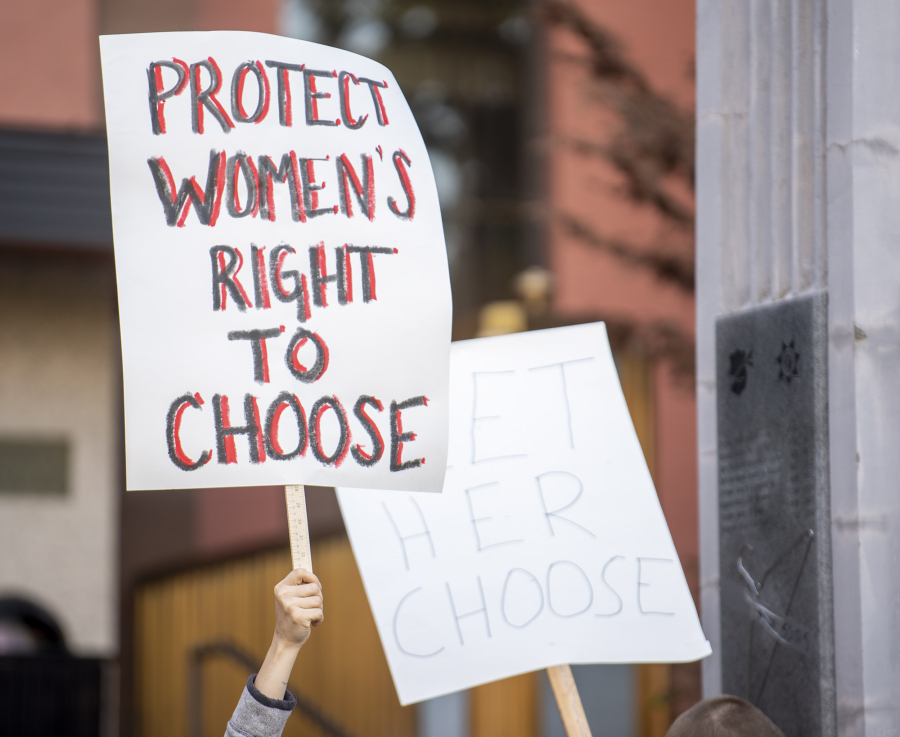 Local abortion rights supporters wave signs Tuesday evening.