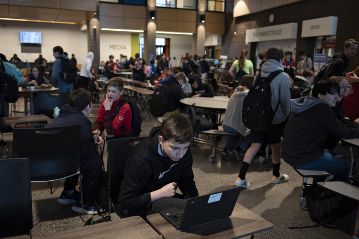 Seventh-grader Iiaston Kory, 12, foreground, joins fellow students as they gather in the cafeteria at View Ridge Middle School before school earlier this month. District officials have identified the View Ridge complex, which shares space with Sunset Intermediate School, as perhaps the most crowded place in the district. Possible plans to alleviate overcrowding at the school include converting extracurricular spaces like the wrestling room and theater to new classrooms.