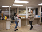 Linda Mouy, left, holds daughter Nina, 3, while her husband, Sonny, holds their other daughter, Isla, 1, as they talk about Short and Sweet, a boba, mochi doughnut, and banh mi shop they are creating in the former location of Rosemary Cafe.