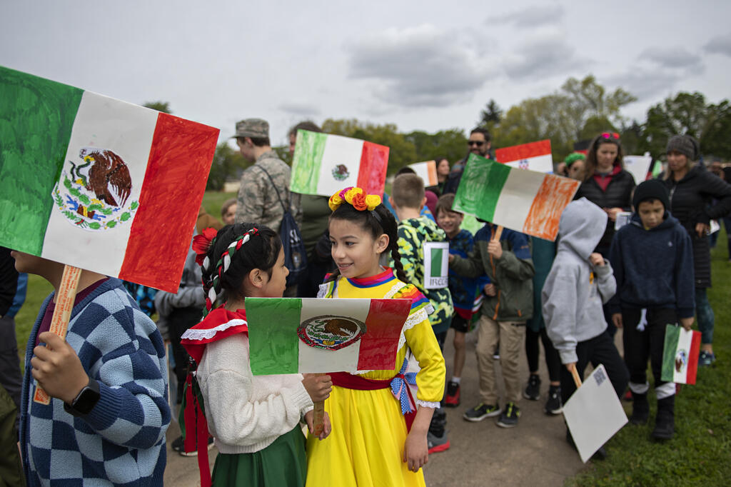 Harney Elementary School third-graders Amber Kanekoa, 8, in green skirt, and Emily Perez, 9, right in yellow, join classmates during the annual Children's Culture Parade at Fort Vancouver National Historic Site on Friday morning, May 13, 2022. The National Park Service and the Evergreen and Vancouver School Districts hosted the annual event.