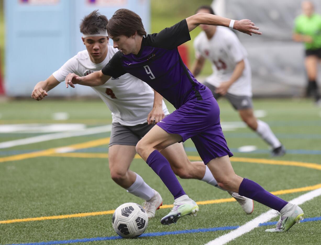 Columbia River's Alexander Harris, right, carries the ball against WF West's Cameron Kunz in the first round of the Class 2A state playoffs.