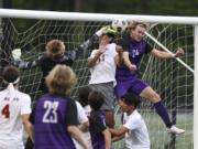 Columbia River's Alexander Brown, right, heads the ball at the goal as WF West's Hayden Sciera, left, and Ezra Bolin, center defend in the first round of the Class 2A state playoffs.