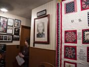 Janie Peto pauses in the hallway of her Vancouver home to view a portrait of her son, U.S. Marine Corps Sgt. Jason Peto. He died from injuries sustained during his service in Sangin, Afghanistan, in 2010.