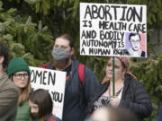 A person holds a sign with an image of former Supreme Court Justice Ruth Bader Ginsburg as they take part in a rally in favor of abortion rights, Tuesday, May 3, 2022, at the Capitol in Olympia, Wash. (AP Photo/Ted S.