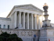 FILE - The sun rises behind the U.S. Supreme Court in Washington, on Nov. 10, 2020. The federal government is warning law enforcement agencies around the nation of the increased potential for extremist violence following the leak of a draft Supreme Court opinion striking down the constitutional right to abortion.